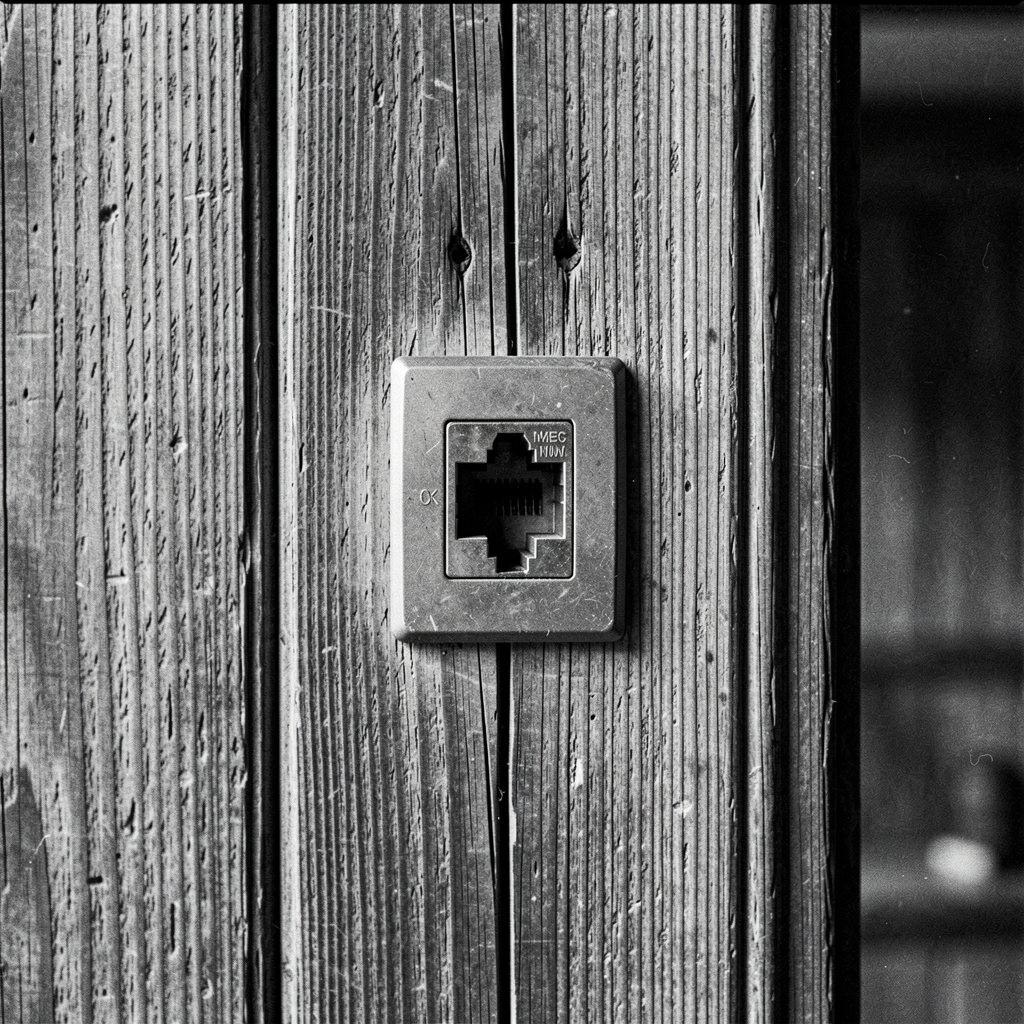 An unused ethernet wall port in the historic town hall — a visual metaphor for the disconnect between Willow Creek's heritage and its digital future.